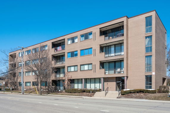 Front view of a four-story apartment building with multiple balconies.