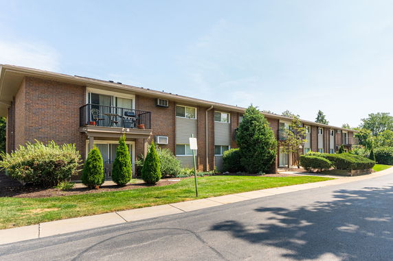 Front view of a two-story brick apartment building with balconies.