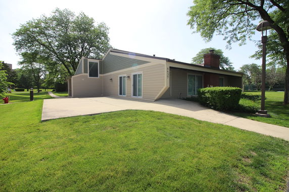 Front view of a single-story house with large windows and sliding doors.