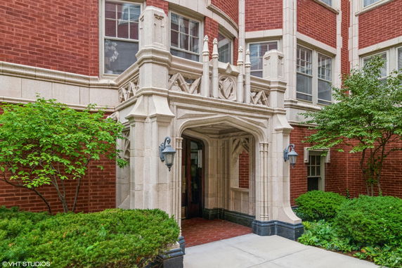 Front view of a building entrance with ornate stonework and brick facade.