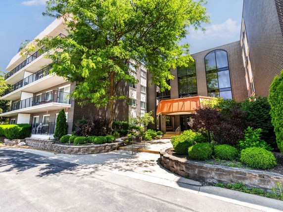 Front view of a multi-story residential building with balconies and a welcoming entrance.
