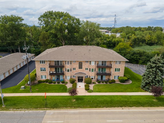 Front view of a multi-story apartment building with brick exterior and balconies.