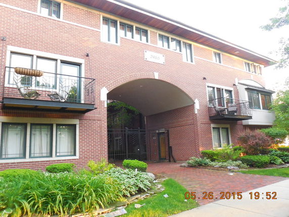 Front view of a multi-story brick building with balconies.