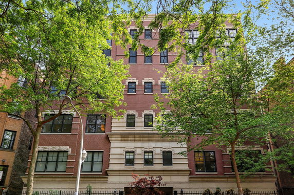 Front view of a multi-story brick building with decorative stone detailing.