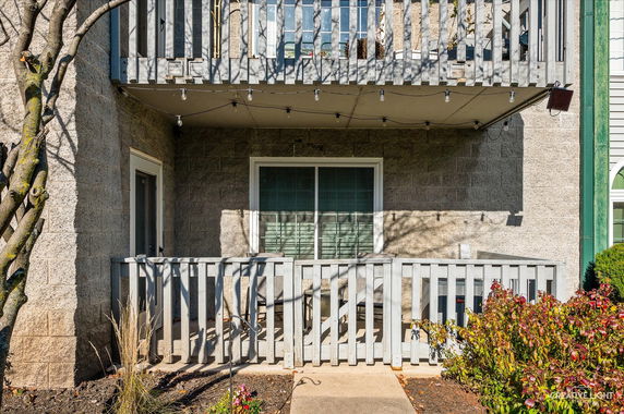 Front view of a building with a balcony and patio area.