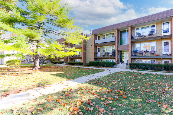 Front view of a multi-story apartment building with balconies.