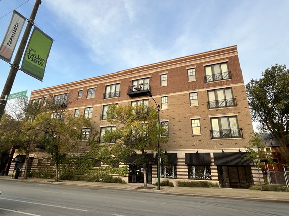 Front view of a multi-story brick building with balconies.