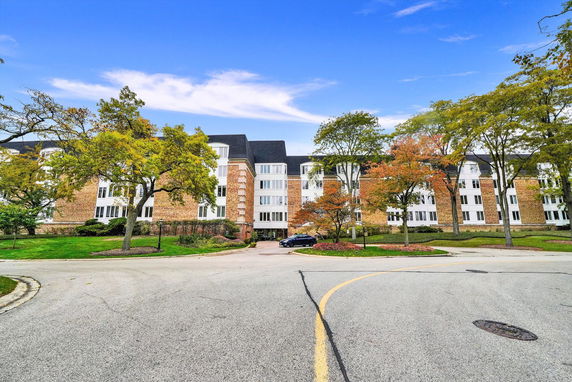 Front view of a multi-story residential building with brick and white facade.
