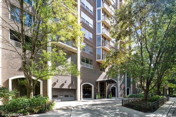 Front view of a multi-story apartment building with a brick facade.