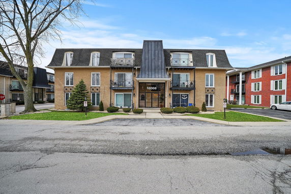 Front view of a multi-story apartment building with a central entrance.