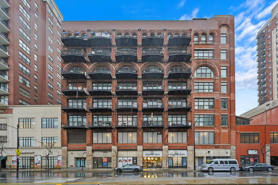 Front view of a multi-story brick building with multiple balconies and large windows.