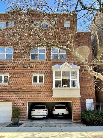 Front view of a three-story brick house with a double garage.