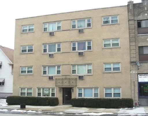 Front view of a multi-story apartment building with a brick facade.