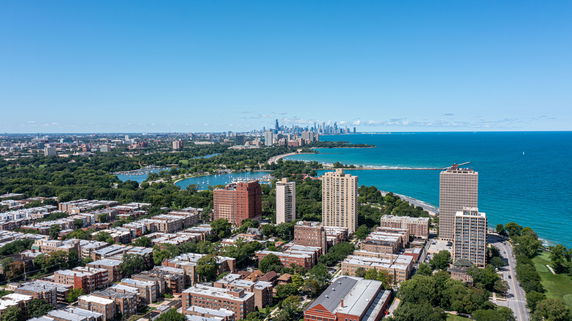 Panoramic view of a coastal city with high-rise buildings and a large body of water.