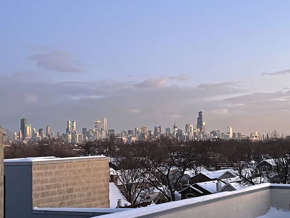 Panoramic view of a city skyline from a rooftop during dusk.