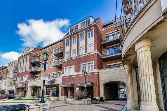 Front view of a multi-story brick building with balconies and decorative columns.