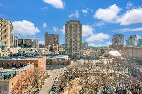 Panoramic view of a city landscape with multiple high-rise buildings under a clear blue sky.