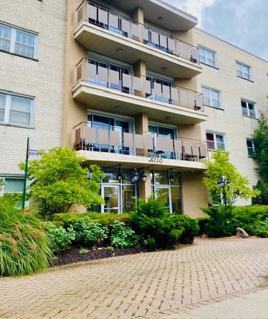 Front view of a multi-story apartment building with balconies.