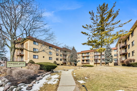 Front view of a multi-story apartment building with balconies.