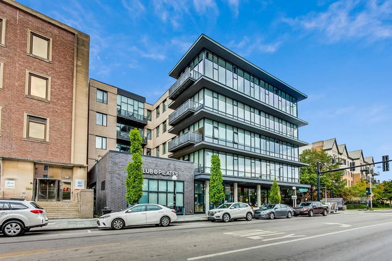 Front view of a modern multi-story building with large glass windows.