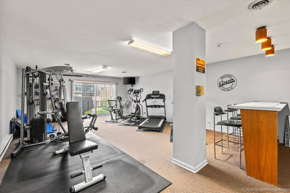 Indoor gym with exercise equipment and seating area.