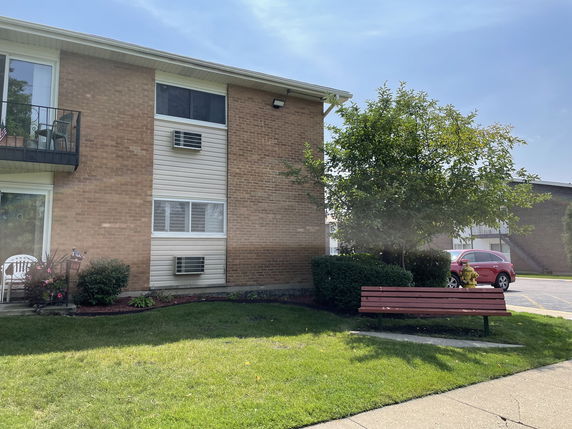 Front view of a multi-story brick building with balconies.