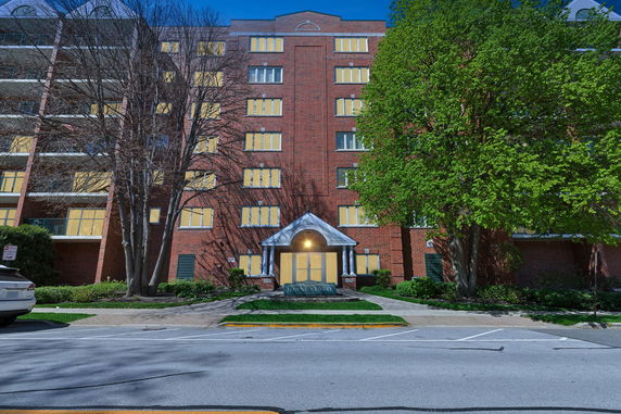 Front view of a multi-story brick building with numerous windows and a central entrance.