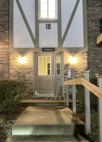 Front view of a building entrance with lights and a pathway.