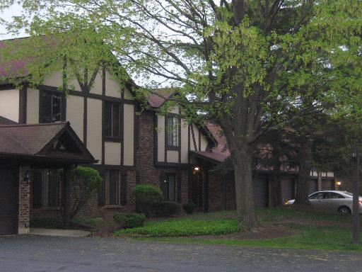 Front view of a two-story house with Tudor-style architecture and attached garages.