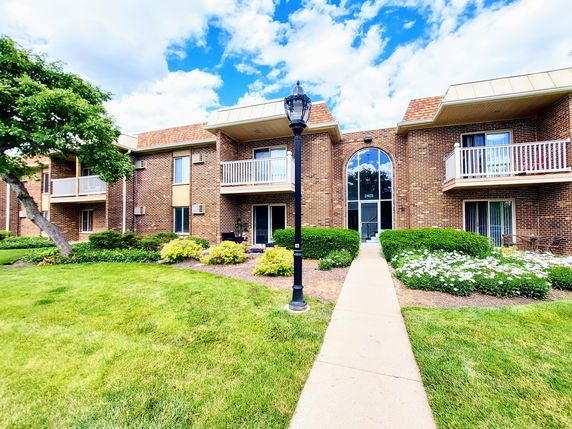 Front view of a two-story brick residential building with balconies.