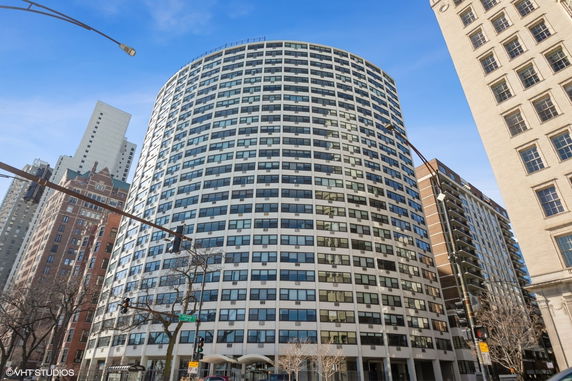 Front view of a tall, curved glass building.