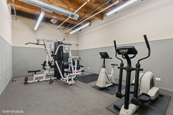 Interior view of a gym with exercise machines and equipment.