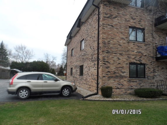 Side view of a brick two-story building with several windows.