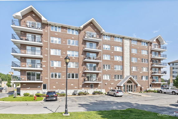 Front view of a multi-story apartment building with balconies on each side.