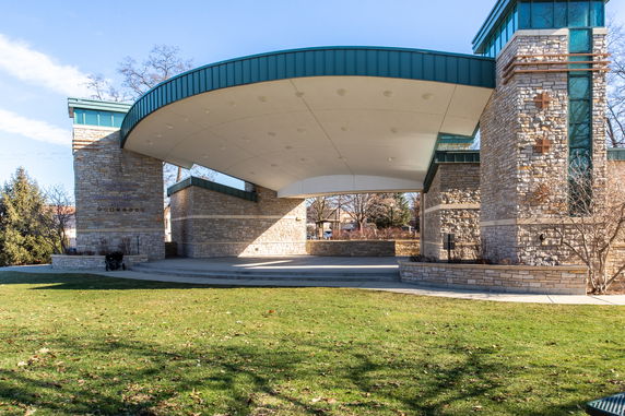 Front view of a stone pavilion with a large curved roof.