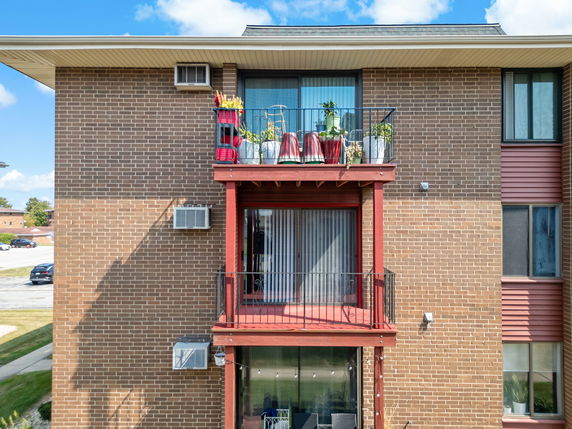 Front view of a brick apartment building with balconies.