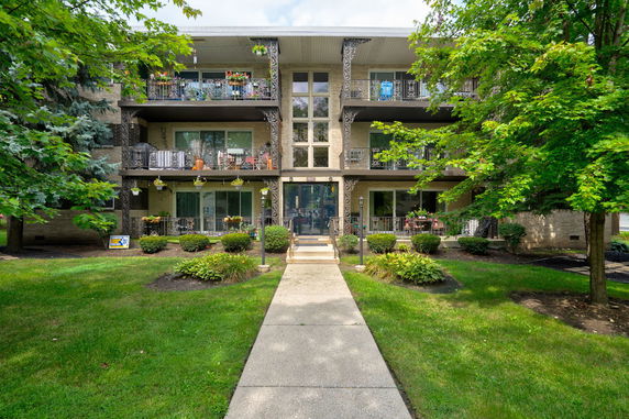 Front view of a three-story apartment building with balconies.