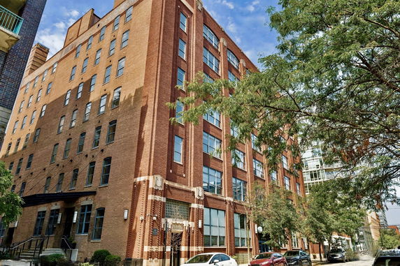 Front view of a multi-story brick building with large windows.