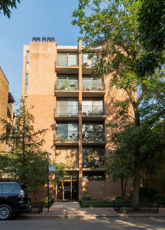 Front view of a multi-story apartment building with balconies.