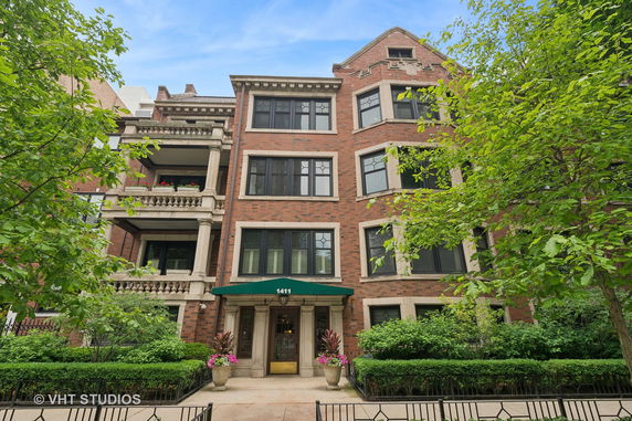 Front view of a multi-story brick residential building with balconies.