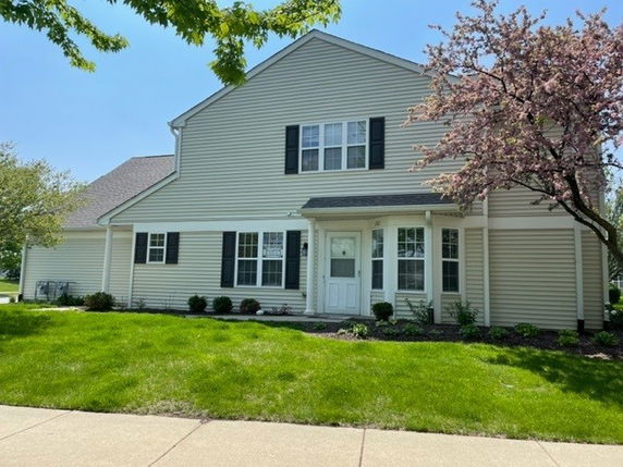 Front view of a two-story house with siding and multiple windows.