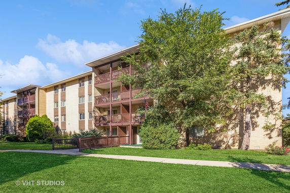Front view of a multi-story apartment building with balconies.