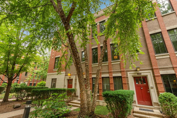 Front view of a multi-story brick building with red doors.
