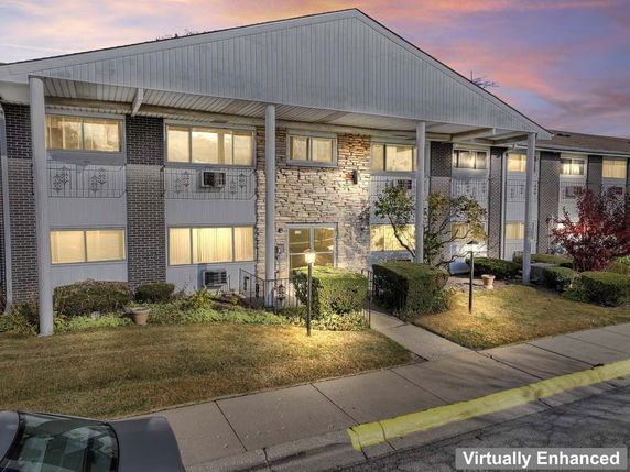 Front view of a multi-story building with large pillars and stone accent walls.