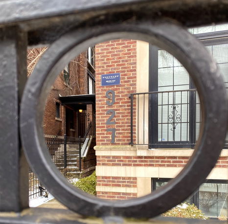 Front view of a brick building with metal railings and address number 927.