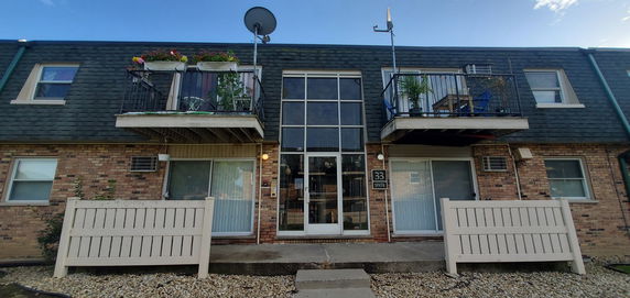 Front view of a two-story apartment building with brick facade and small balconies.