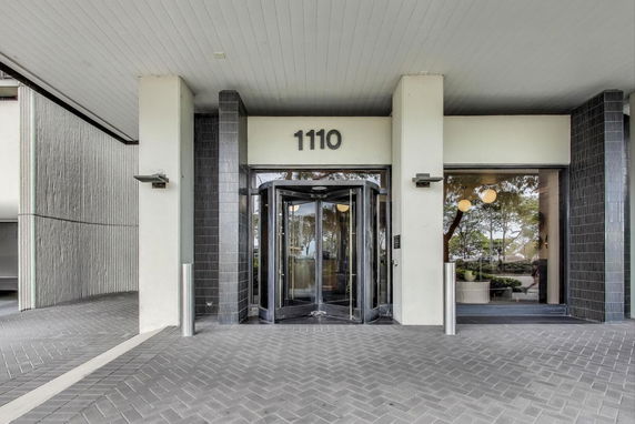 Front view of a building with a revolving door entrance and building number 1110.