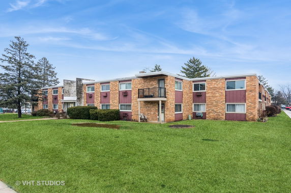 Front view of a mid-century apartment building with brick and paneling exterior.