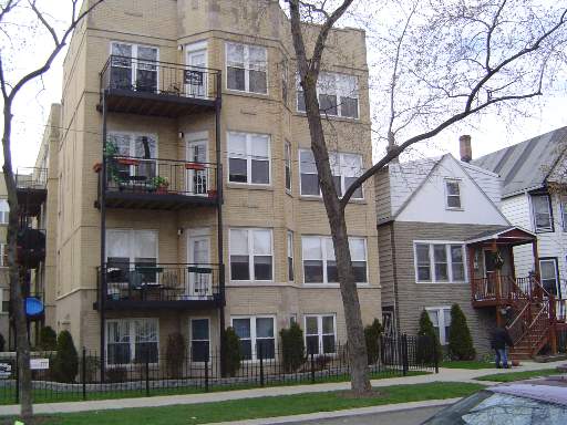Front view of a multi-story residential building with balconies.