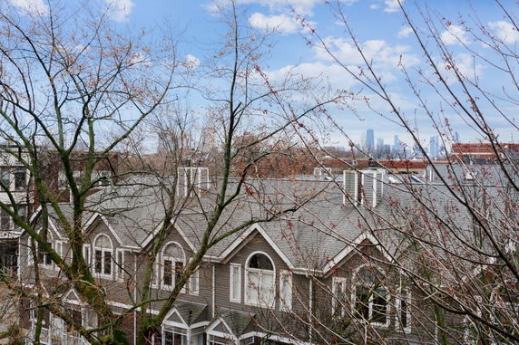 Panoramic view of rooftops with a distant city skyline.
